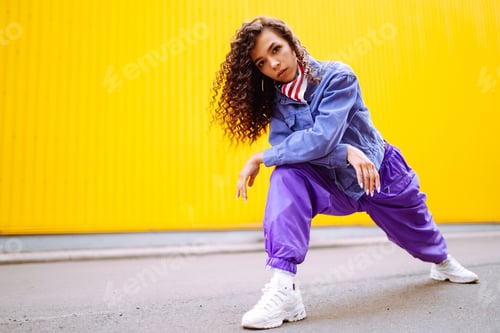 Preview: Funky young woman with american bandana dancing alone in the street.Sport, dancing and urban culture