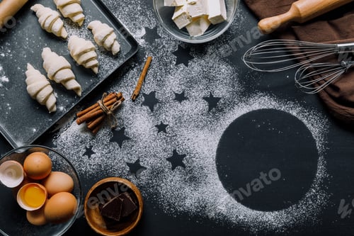 Preview: view from above of tray with dough for croissants and ingredients on table covered by flour with