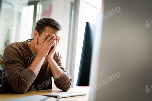 Preview: Portrait of a disappointed man programmer looking stressed out while working on a computer code