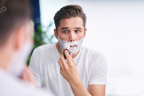 Preview: Portrait of adult man shaving in the bathroom