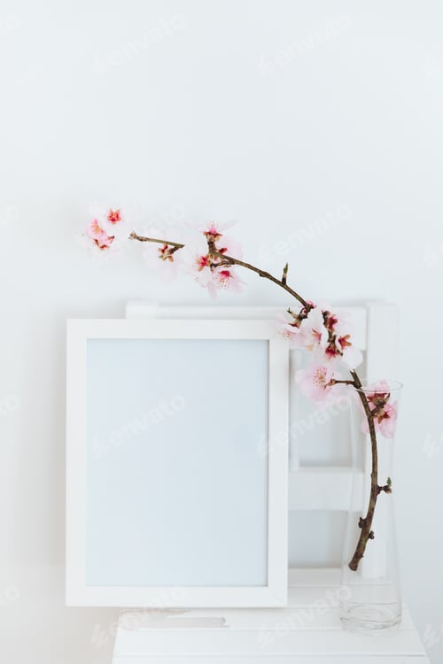Preview: Almond blossom twigs with picture frame mockup. White background, copy space.