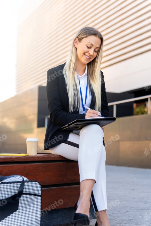 Preview: Romanian real estate business woman smiling taking notes in her notebook