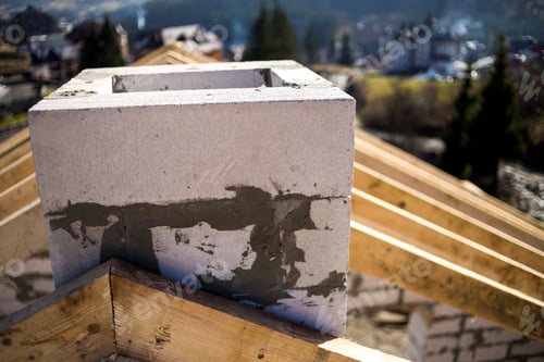 Preview: Close-up detail of roof frame of rough wooden lumber beams and chimney