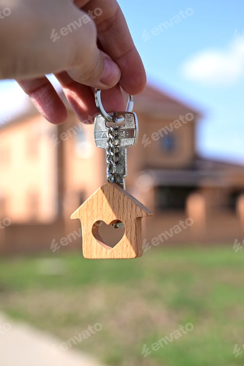 Preview: a key with a keychain in the form of a house with a heart on the background of the finished year of