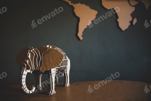 Preview: World map and elephant figurine on wooden table with blackboard background