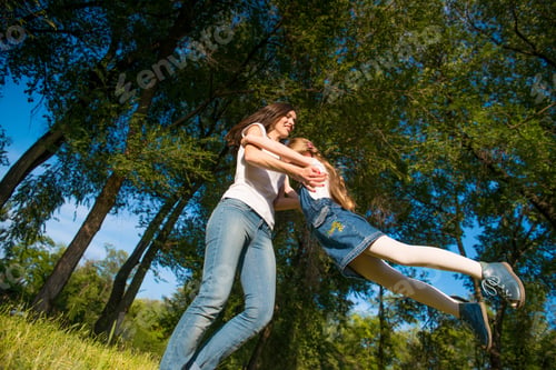 Preview: Mom is spinning her daughter holding her hands