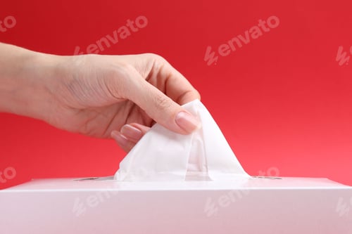 Preview: Woman taking handkerchief out of box on red background, closeup