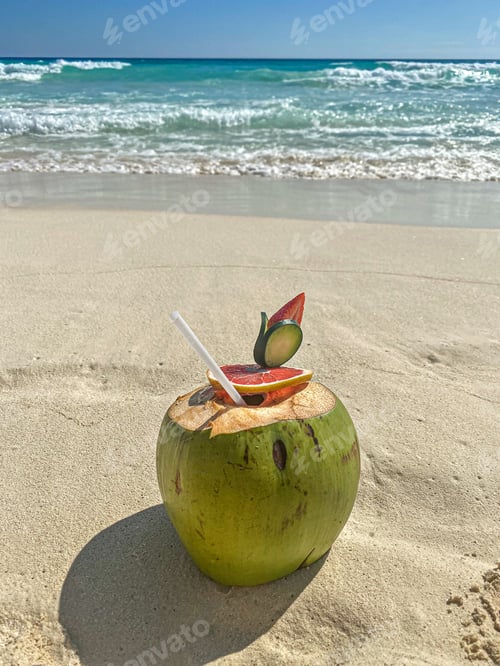 Preview: Fresh young coconut with juice straw on the sand beach. tropical vacation.