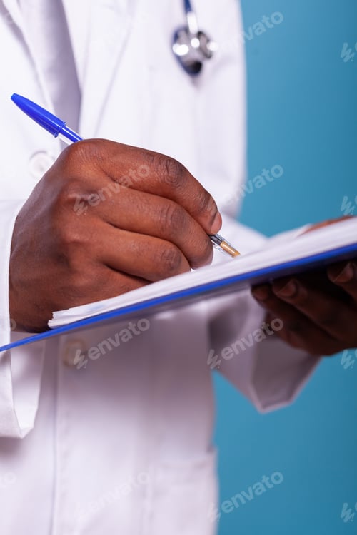 Preview: Closeup of african american doctor hand holding ballpoint pen writting on clipboard