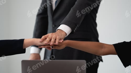Preview: Close Up of diverse team of professionals engaging in a teamwork handshake.