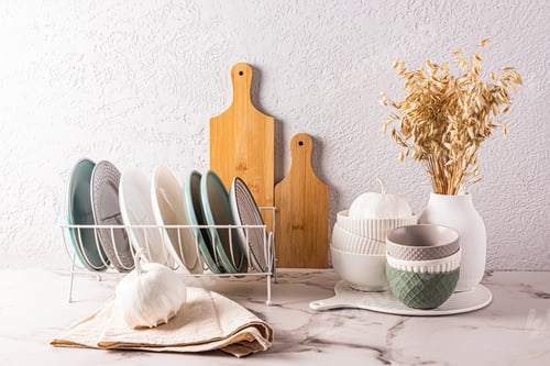 Preview: A set of ceramic bowls, plates in a plate dryer, decorative pumpkins on the kitchen countertop.