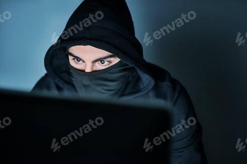 Preview: Hes on the hunt for your passwords. Shot of a young hacker using a computer late at night.
