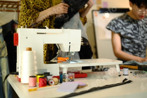Preview: Close up of a modern sewing machine with thread and tools in a designer workspace