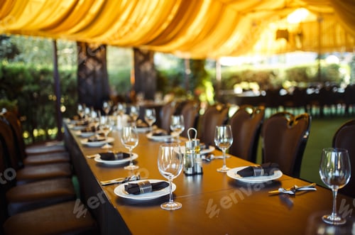Preview: Sparkling glassware stands on long table prepared for wedding dinner.