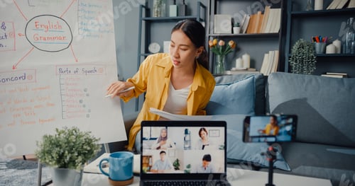 Preview: Asia lady english teacher video conference calling on smartphone talk by webcam.