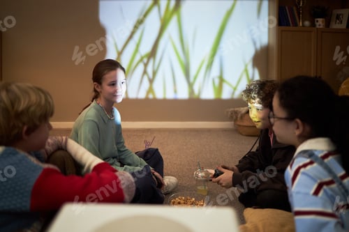Preview: Group of Preteen Children Watching Movie and Eating Snacks Indoors Together