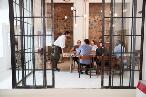 Preview: Young man managing a team meeting in a boardroom