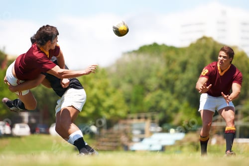 Preview: Working together for stronger unity. Shot of a young rugby player executing a pass mid-tackle.