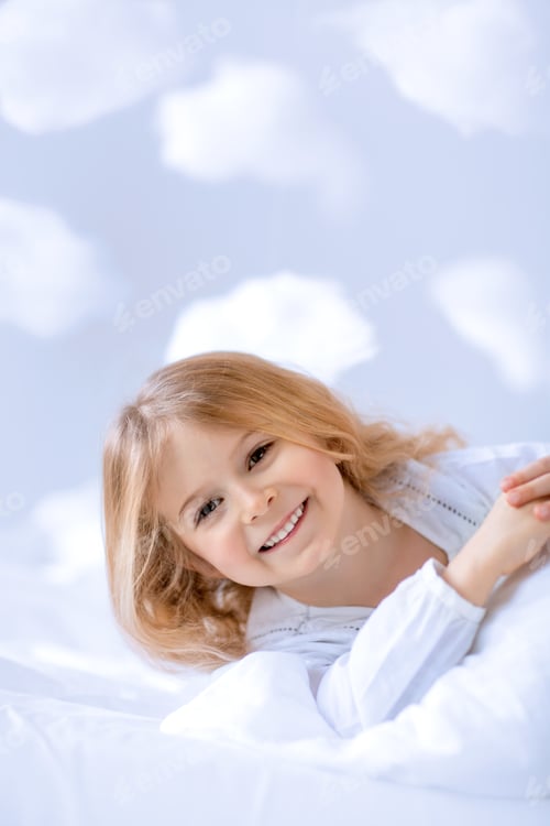 Preview: Smiling Girl Relaxing on White Bedding