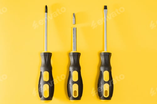 Preview: three black and yellow screwdrivers on a yellow background with space for text. Tools