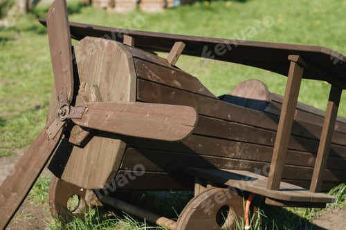 Preview: A wooden model of an airplane standing on the street in summer