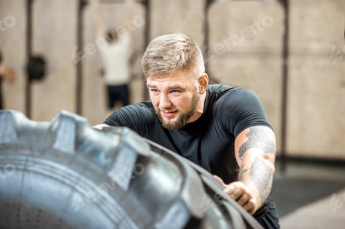 Preview: Man pushing a tire in the gym