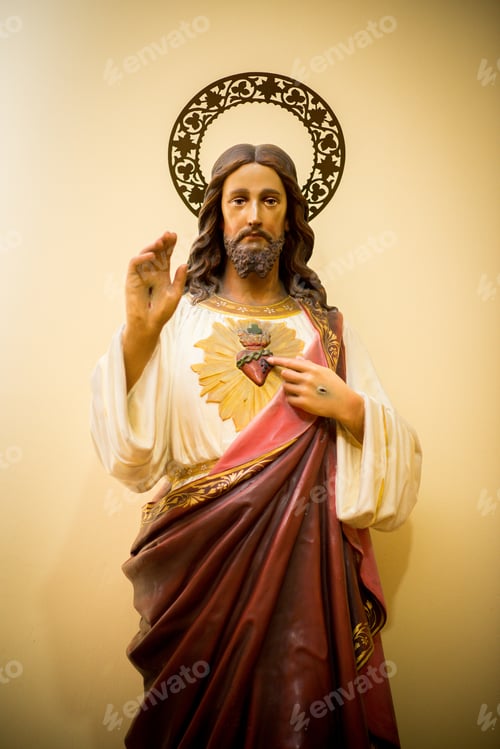 Preview: Vertical shot of a statue of Jesus Christ in a red robe on a yellow background