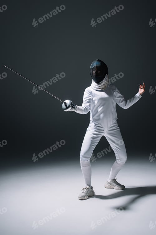 Preview: Fencer in fencing mask training with rapier on white surface on black background