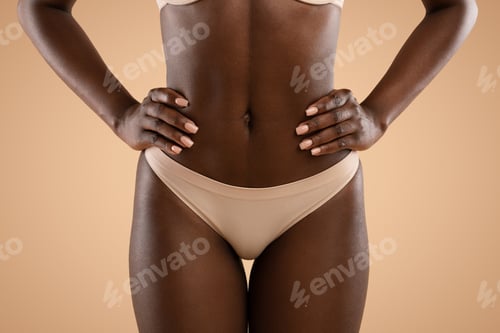 Preview: Slim african american woman demonstrating her flat belly, cropped