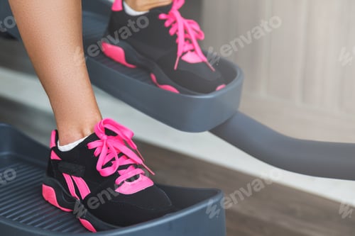 Preview: Female legs on a elliptical trainer in the gym
