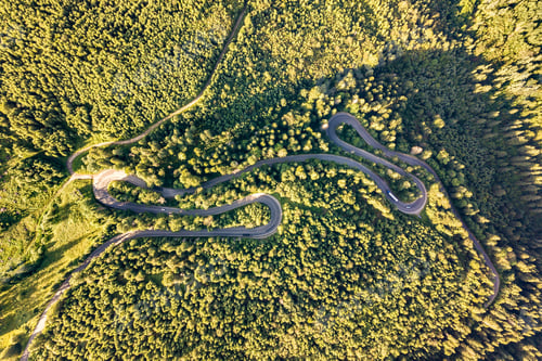 Preview: Aerial view of winding road in high mountain pass trough dense green pine woods.