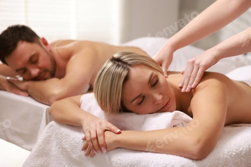 Preview: Couple receiving relaxing massage in spa salon, selective focus