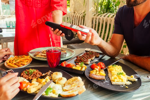 Preview: indian man paying in restaurant by credit card app on smartphone reader
