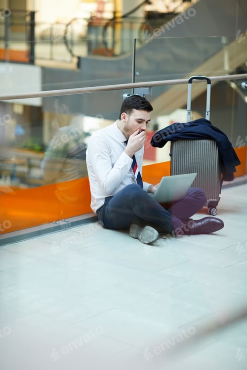 Preview: Bored businessman working in airport