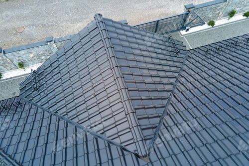 Preview: Closeup of house roof top covered with shiny ceramic shingles.