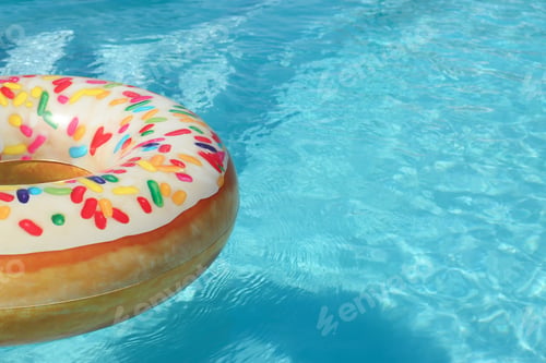 Preview: Bright inflatable doughnut ring floating in swimming pool on sunny day. Space for text