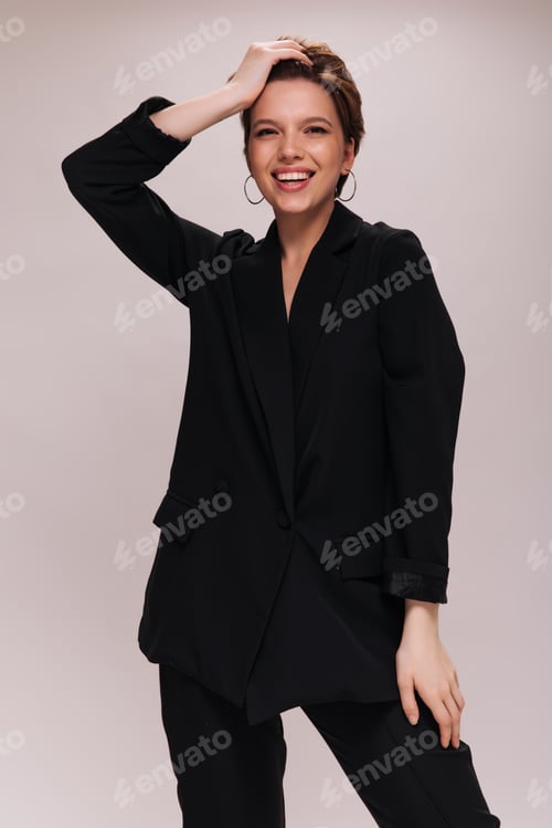 Preview: Charming lady in black classic outfit smiling on isolated background. Attractive woman in dark suit