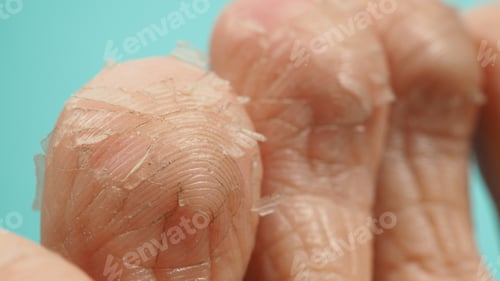 Preview: Close up of Foot peeling or remove dead skin on green or tiffany blue background.