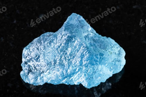Preview: sample of raw aquamarine mineral on black granite