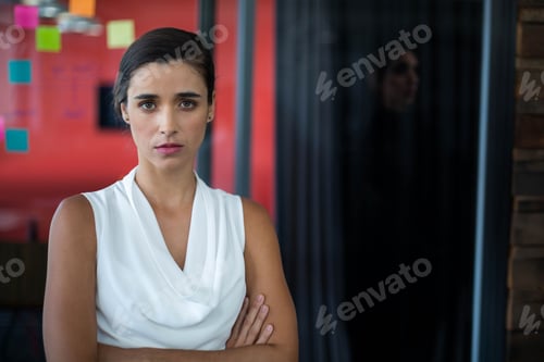 Preview: Woman standing in office room surveying sticky notes on red accent wall through glass partition