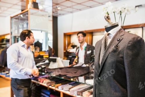Preview: Customer talking with tailor in clothing store
