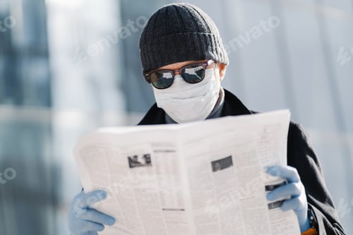 Preview: Photo of European man wears protective medical mask and gloves, walks through city outdoor