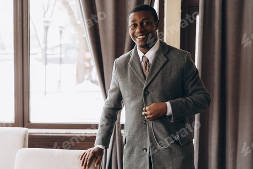 Preview: African American businessman smiling confidently wearing overcoat in cafe