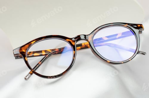 Preview: Leopard-colored glasses on a white silk fabric
