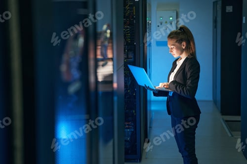 Preview: Female engineer working in server room at modern data center