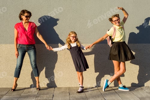 Preview: Back to school, mom and two daughters primary school girl and teenager walking together