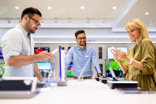 Preview: Happy seller man helping to people to buy a new digital smart devices in tech store.