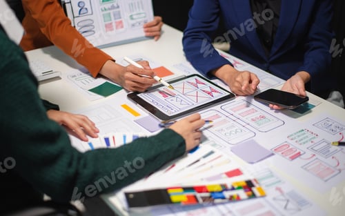 Preview: Close up view of UI developer team brainstorming on their project with laptop, smartphone