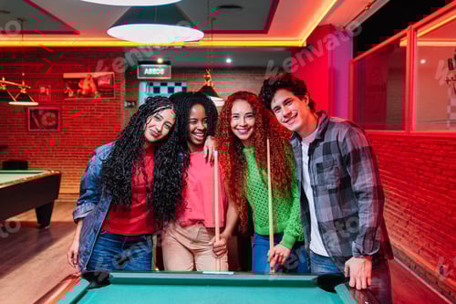 Preview: Happy friends playing billiards in a bowling alley and arcade video game room