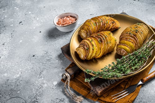 Preview: Baked Hasselback Potato with Fresh thyme and rosemary. Gray background. Top view. Copy space